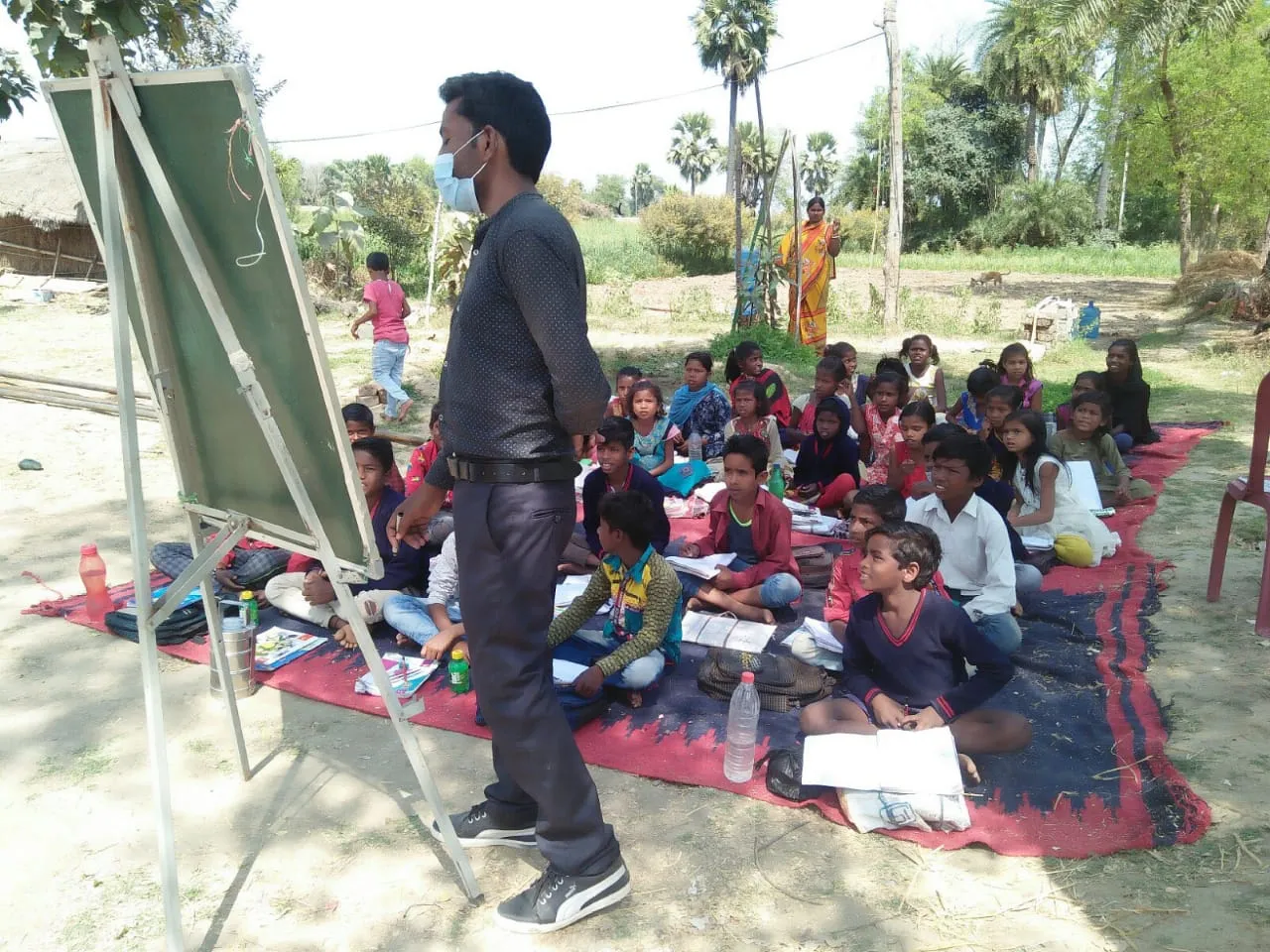 A teacher works with young students in an informal class at Prajna Vihar School in Bodhgaya.